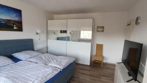 a bedroom with a bed and a flat screen tv at Rothaarsteig Ferienhaus in Kirchhundem