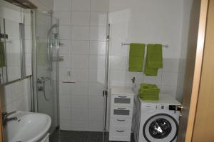 a bathroom with a shower and a washing machine at Rothaarsteig Ferienhaus in Kirchhundem