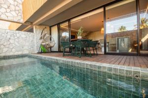 una piscina con tavolo e sedie accanto a una casa di Triplex 3 Suítes Piscina e Hidro para até 12 pessoas a Tatuamunha