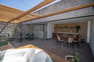 un patio con tavolo e sedie su un ponte di Triplex 3 Suítes Piscina e Hidro para até 12 pessoas a Tatuamunha