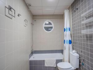 a bathroom with a toilet and a tub and a sink at Apartment in Peñaflor with Charming Patio in Peñaflor +32 photos