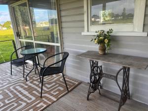 a table and chairs on the porch of a house at Peaceful private and semi rural in Marton