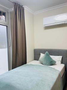 a bedroom with a bed with a green pillow on it at eco Appartements Reichel in Baden-Baden