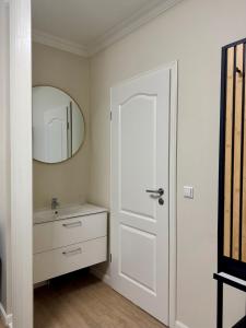 a white bathroom with a sink and a mirror at eco Appartements Reichel in Baden-Baden +1 photo