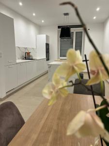 a kitchen with a table with yellow flowers on it at Chambre Élégance et confort a Esch in Esch-sur-Alzette