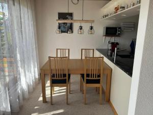 a kitchen with a wooden table and two chairs at Stockenmatt Haus 2, Wohnung 22 in Stalden