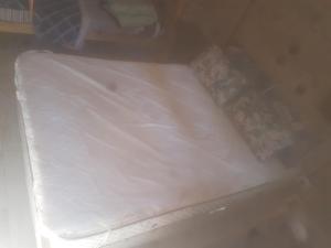 a bed with white sheets and pillows on it at El bosque suite in José León Suárez