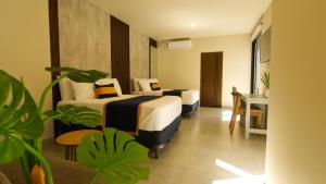 a hotel room with two beds and a desk at Hotel Tiffany in Flores