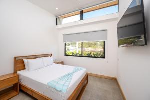 ein Schlafzimmer mit einem Bett und einem Fenster in der Unterkunft Casa Peace with salt water pool 4BR 4BR in Tamarindo + 41 Fotos