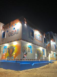 un edificio con pinturas al costado de él por la noche en OBAI Nubian Guest House, en Jazīrat Aswān