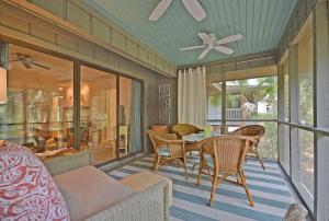 a screened in porch with a table and chairs at IC106: 106 Inlet Cove in Kiawah Island