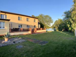 a house with a yard in front of it at Ferienwohnungen Zur Biberburg in Friedrichswalde