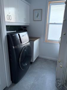 a laundry room with a washing machine and a window at Maison d edouard in Saint-Antonin