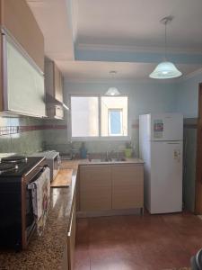 a kitchen with a white refrigerator and a sink at La Bendita in Posadas +18 photos