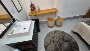 a bathroom with a sink and two trash cans at Stúdio 7 climatizado, centro-terreo-privativo in Domingos Martins