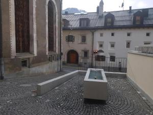 a bench sitting on the side of a building at Chesa Quadrella in Pontresina