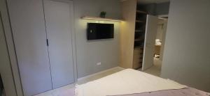 马德普拉塔Alquileres Corrientes的一间卧室，墙上有一张床和一台电视