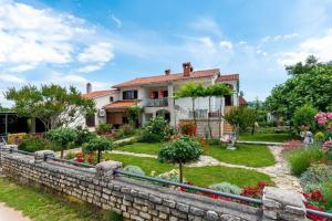 a house with a retaining wall and a garden at Vinez in Labin