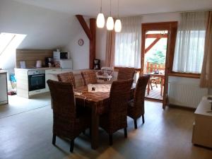 a kitchen and dining room with a wooden table and chairs at Fügefa Vendégház in Orfű