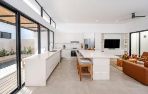 eine offene Küche mit weißen Schränken und einer großen Insel in der Unterkunft Casa Peace with salt water pool 4BR 4BR in Tamarindo