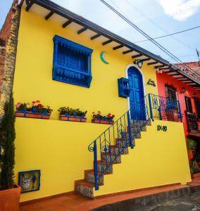 a yellow house with blue doors and stairs at Casa Amarilla in San Gil