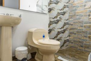 a bathroom with a toilet and a sink and a shower at Hotel Salinero - Zipaquirá in Zipaquirá