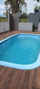 a large blue swimming pool on a wooden deck at Estância arco iris in Regente Feijó