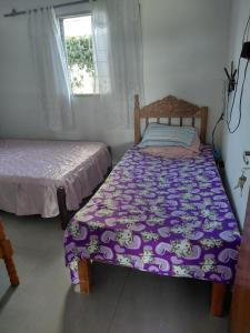 a bedroom with two beds and a window at Estância arco iris in Regente Feijó