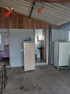 a room with a refrigerator and two birds on the ceiling at Estância arco iris in Regente Feijó