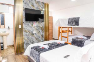 a bedroom with two bunk beds and a tv at Hotel Salinero - Zipaquirá in Zipaquirá