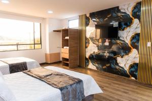 a bedroom with two beds and a wall with a mural at Hotel Salinero - Zipaquirá in Zipaquirá