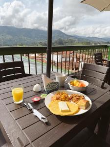 a table with a plate of breakfast food and orange juice at El Despertar Hotel in Jericó