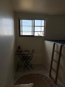 uma pequena sala com uma mesa e uma janela em Hostal ídem em Valparaíso