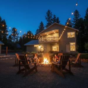 a group of children sitting around a fire in front of a house at Cozy Pine Cabin Pool Access in Ronald