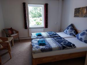 een slaapkamer met een bed met blauwe lakens en een raam bij Fewo Am Skihang Eg in Eibenstock +8 foto's