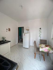 eine Küche mit einem Tisch und einem weißen Kühlschrank in der Unterkunft Sunset loft in São Thomé das Letras