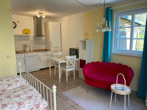 a living room with a red couch and a table at Großzügiges Studio In Einem Kleinen Fachwerkhaus in Dömitz