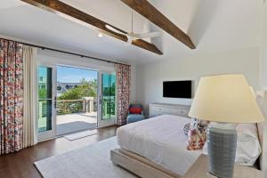 a bedroom with a bed with a lamp and a balcony at SS59: 59 Surfsong in Kiawah Island +71 photos