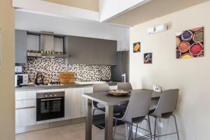 a kitchen with a table and chairs in a room at Intera Struttura in Noto Marina