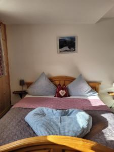 a bedroom with a bed with a heart pillow on it at Fewo Alpenrose in Nesselwängle