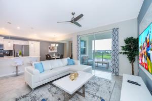 キシミーにある3151-307BE STOREY LAKE, CONDO 2/2 LAKE VIEWの白いソファとテーブルのあるリビングルーム