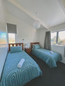 En eller flere senge i et værelse på Raglan Rural Retreats - The Homestead + 25 billeder