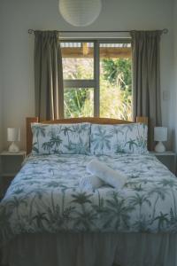 En eller flere senge i et værelse på Raglan Rural Retreats - The Homestead