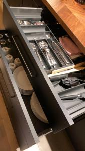 an open drawer with plates and utensils in it at Leilighet i sentrum in Sokndal