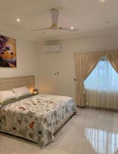 a bedroom with a bed and a window at Legacy Square Apartment in Accra