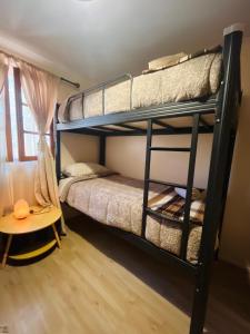 a room with two bunk beds and a table at Cabañas Piedra Viva 2 in San Pedro de Atacama