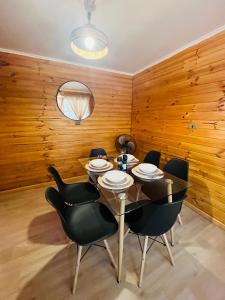 une salle à manger avec une table et des chaises noires dans l'établissement Cabañas San Pedro de Atacama 2, à San Pedro de Atacama