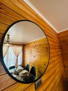 un miroir circulaire dans une pièce avec une table et des chaises dans l'établissement Cabañas San Pedro de Atacama 2, à San Pedro de Atacama