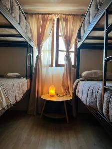 Cette chambre comprend deux lits superposés et une table avec une bougie. dans l'établissement Cabañas San Pedro de Atacama 2, à San Pedro de Atacama