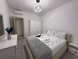een witte slaapkamer met een bed en een witte bar bij Modern 2BR Near City Ring & Main Road Access in Tirana